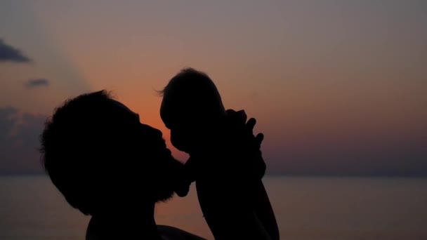 Vader en Baby bij zonsondergang zee close-up. Slow Motion. — Stockvideo