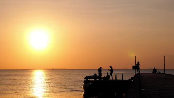 Łódź na molo z turystów na zachodzie słońca — Wideo stockowe