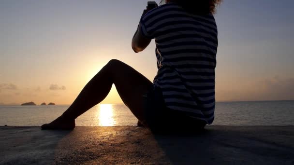 Attraktive Frauensilhouette mit Smartphone bei Sonnenuntergang — Stockvideo