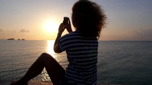 Femme prenant des photos du coucher du soleil avec appareil photo intelligent — Video
