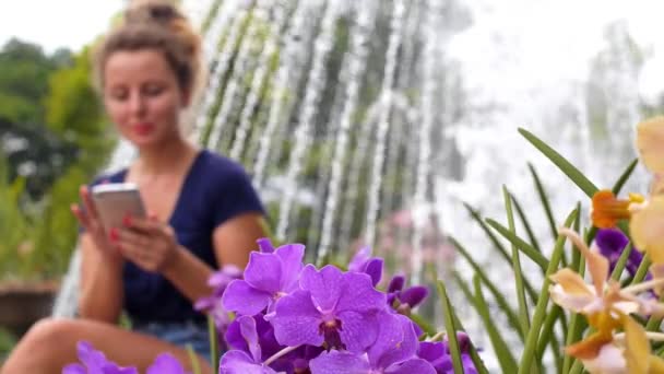 Leende ung kvinna med hjälp av mobiltelefon i vacker Park — Stockvideo