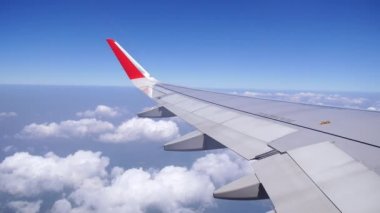 Bulutların üzerinde uçan bir uçağın kanadı.