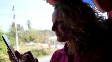 Otobüsle seyahat ederken akıllı telefon kullanan genç kadın