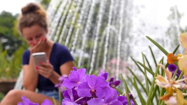 Gelukkig lachend meisje met behulp van mobiele telefoon in stadspark — Stockvideo