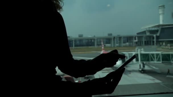 Mujer viajera usando teléfono inteligente en el aeropuerto en la zona de espera — Vídeos de Stock