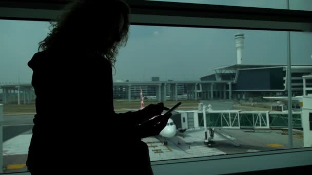 Vrouw met behulp van slimme telefoon mobiel in Airport Terminal — Stockvideo