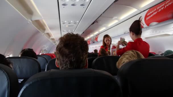 Interior del avión con pasajeros en asientos y azafata — Vídeos de Stock