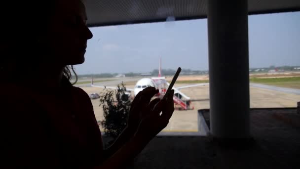 Vrouw met behulp van slimme telefoon mobiel in Airport Terminal — Stockvideo