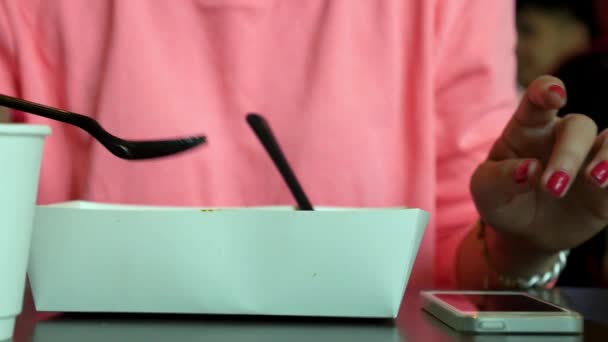 Mujer joven usando Smartphone y almorzando — Vídeos de Stock