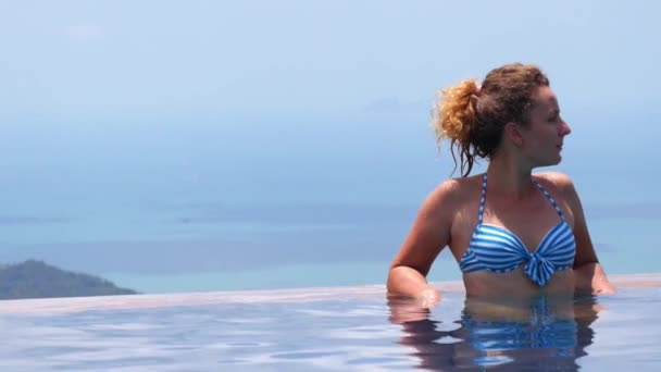 І натхненний вид на море з дівчиною в басейні — стокове відео