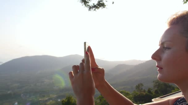 Jeune femme prendre des photos avec téléphone portable en plein air — Video