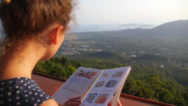 Giovane donna Scegliere da un menu ristorante all'aperto — Video Stock