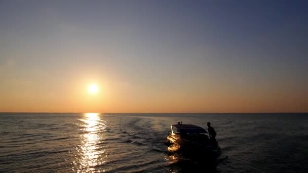 Barco a motor navegando en el mar contra la puesta del sol — Vídeo de stock