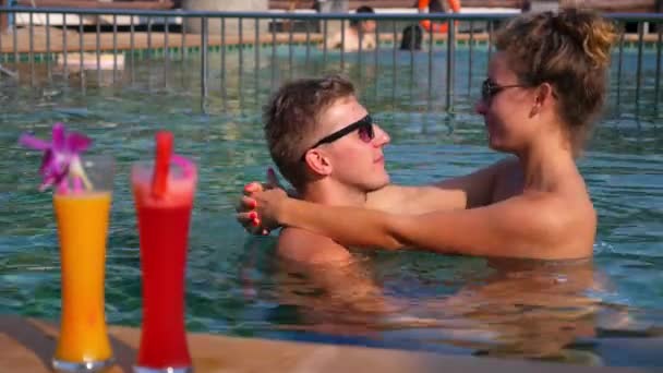 Pár pihentető az egészséges italok napos medencével — Stock videók