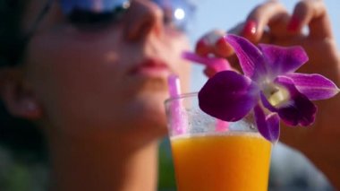 Gülümseyen kadın açık havada taze meyve suyu içme. Ağır çekim.
