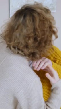 Yaşlı anne sevgiyle yetişkin kızını kucaklıyor. Sevgisini, rahatlığını ve güçlü aile bağlarını birbirlerine yakın tutarak ifade ediyor.