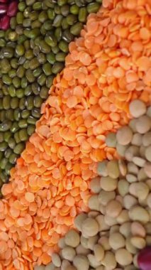 Çeşitli renklerde ham baklagiller, kırmızı fasulye, yeşil mercimek, turuncu mercimek ve mung fasulyesi, sağlıklı beslenme ve vejetaryen kavramları için mükemmel bir arka plan.