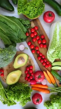 Temiz yemek için domates, avokado, marul, havuç ve brokoliden oluşan taze organik sebzeler ve sebzeler içeren sağlıklı gıda konsepti.