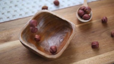 Ağır çekim görüntüler, tüm ham fındıkların küçük bir ahşap kaseye düşüşünü gösteriyor. Besleyici ve sağlıklı bir atıştırmalık konsepti.