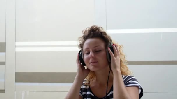 Chica bailando sonriendo y riendo con auriculares escuchando música . — Vídeos de Stock