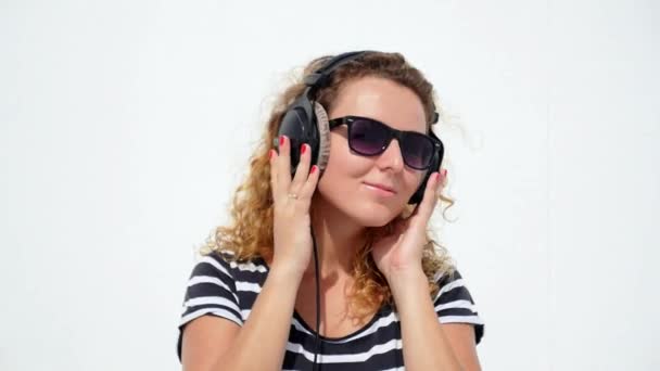 TAILANDIA, KOH SAMUI, DICIEMBRE DE 2014 - Mujer joven con auriculares contra fondo blanco. Moción lenta . — Vídeos de Stock