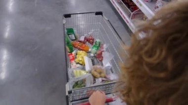 Markette tramvayla alışveriş yapan bir kadın.