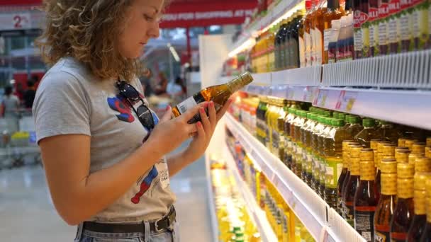 Thailand, koh samui, 09.09.2015 - Frau im Supermarkt kauft Lebensmittel, Olivenöl — Stockvideo