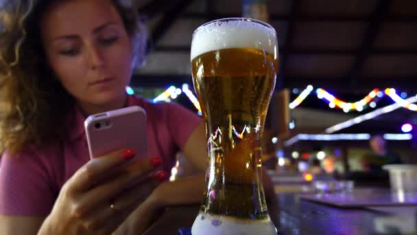 Mujer escribiendo mensaje de texto en el teléfono inteligente en la barra — Vídeo de stock