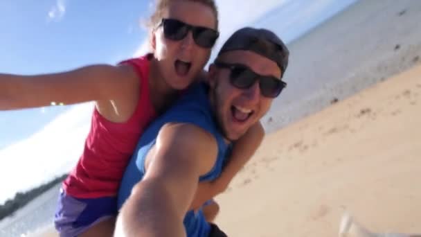 Счастливая спортивная пара, смеющаяся на пляже — стоковое видео