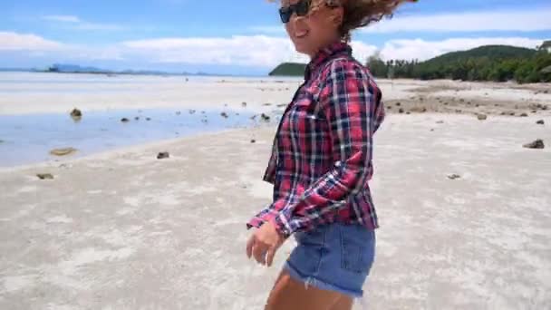 Щаслива молода жінка на пляжі в контрольній сорочці — стокове відео