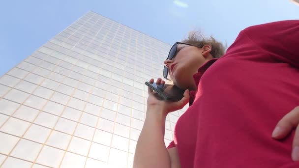 Деловая женщина разговаривает по смартфону в городе в офисном здании — стоковое видео