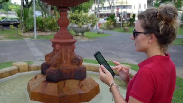 Fille en utilisant la tablette de plein air dans le parc en ville — Video
