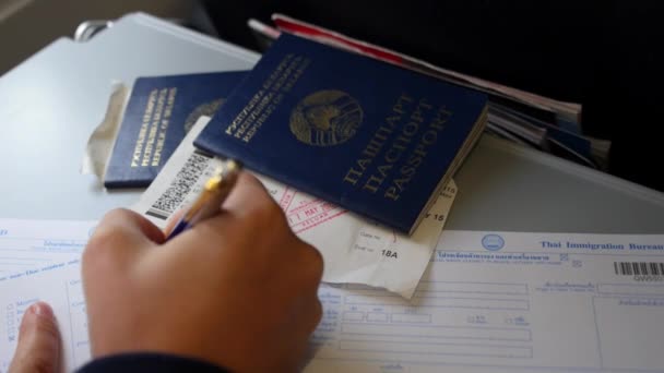 Closeup της πλήρωσης κάρτα μετανάστευσης με διαβατήρια — Αρχείο Βίντεο