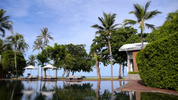 Transats vides au bord de la piscine Resort avec vue sur la mer sur la plage 