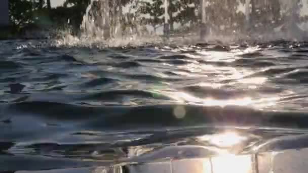 Επιφάνεια ύδατος με ήλιο αντανάκλαση στην κρήνη με το πιτσίλισμα ρεύμα — Αρχείο Βίντεο