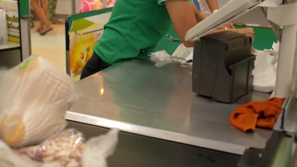 Kassiererin mit Waren an der Kasse im Supermarkt — Stockvideo