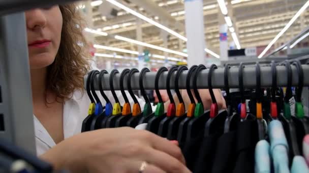 Woman Choosing Dress During Shopping at Garments Apparel Clothing Shop — Stock Video