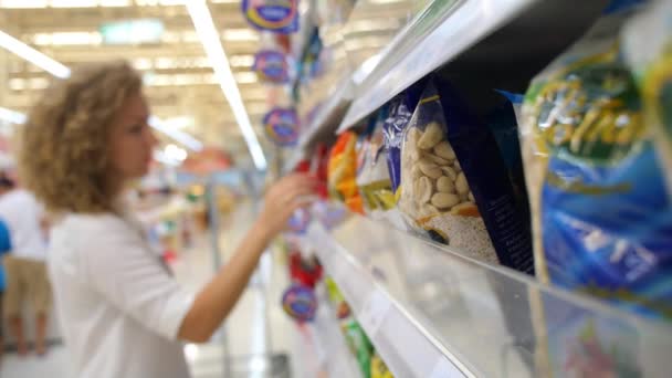 Vrouw bij supermarkt kiezen van voeding — Stockvideo