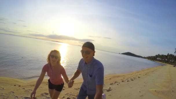 Felice stile di vita coppia in esecuzione sulla spiaggia di sabbia al tramonto — Video Stock