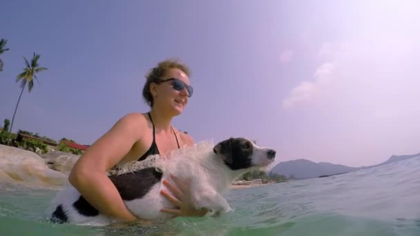 Glad kvinna med hund simma i havet — Stockvideo