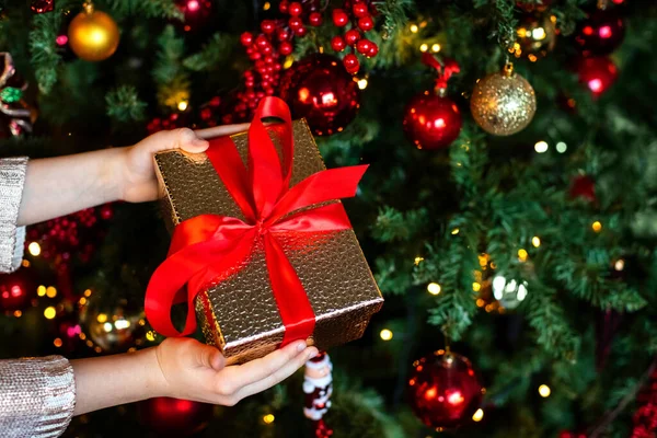 Presente Natal Nas Mãos Uma Criança Fundo Uma Árvore Natal — Fotografia de Stock