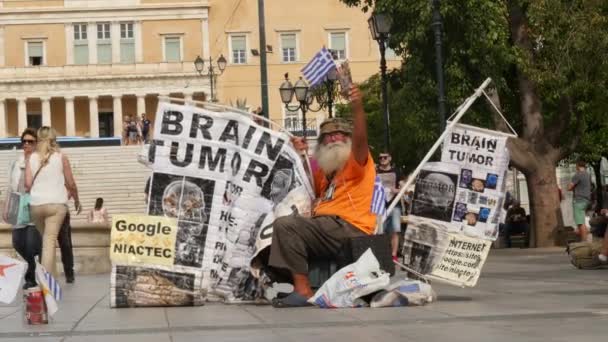 Людина з грецький прапор і банери протесту в центрі Афін — стокове відео