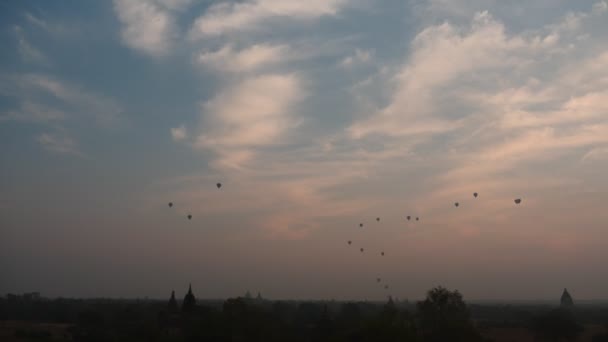 Balões de ar filme hiperlapso panorâmico de longe sob Bagan - antigo local de adoração de Mianmar — Vídeo de Stock