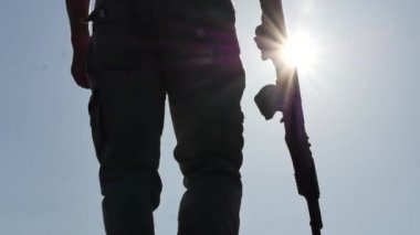 Kalaşnikof saldırı tüfeği siluet adamla yukarı hareket onun el yavaş yükseltir