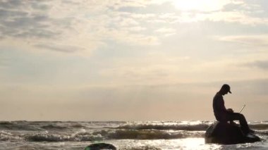 Deniz dissapears doğa panorama dolly vuruşta kaya üstünde defter olan adam