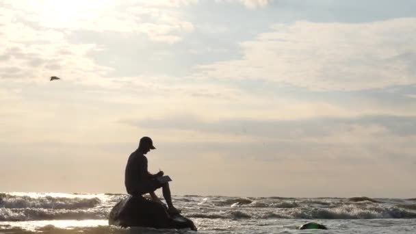 Homem inspirado na rocha no mar tempestuoso escrita - dolly shot — Vídeo de Stock