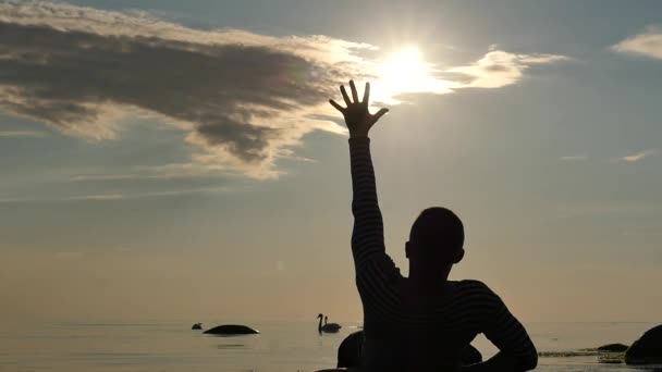 Allongé perdant homme tendu toucher le soleil dans les dernières minutes de la vie au ralenti - silhouette — Video