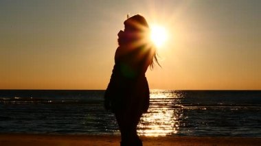 Kadının siluet bir deniz kıyısı yavaş hareket, sıcak çay içmek