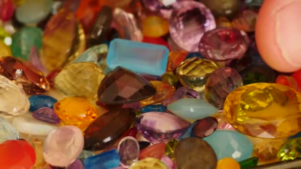 Man fingers move and turn some precious gemstones — Stock Video