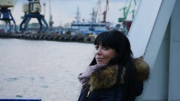 Woman in warm clothes on the swinging boat in port portrait slow motion — Stock Video